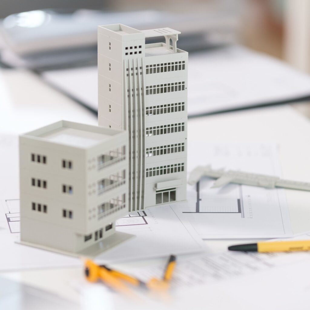 Architectural model on desk with laptop, drawing technical tools and blueprints. Architecture, building, construction and real estate business.