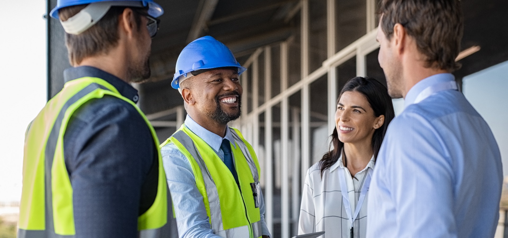 Ingenieur und Geschäftsmann schütteln sich auf der Baustelle die Hände